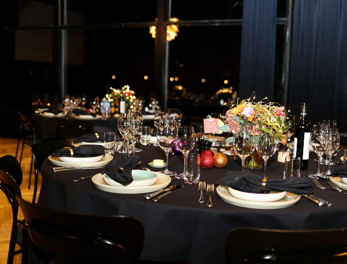 A formal dinner table setting with black tablecloth.